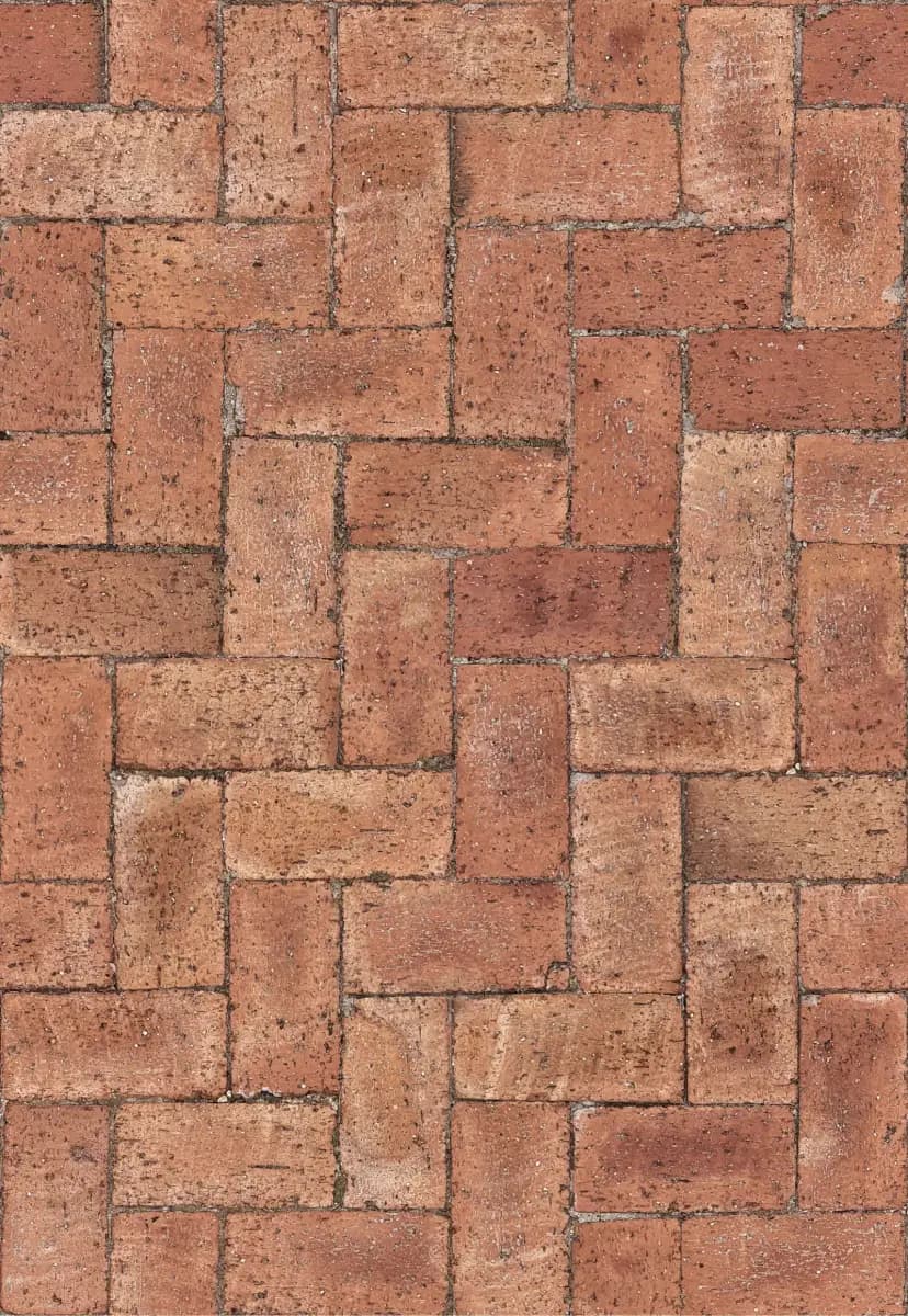 Close-up of red clay-coloured paving bricks laid in a herringbone pattern